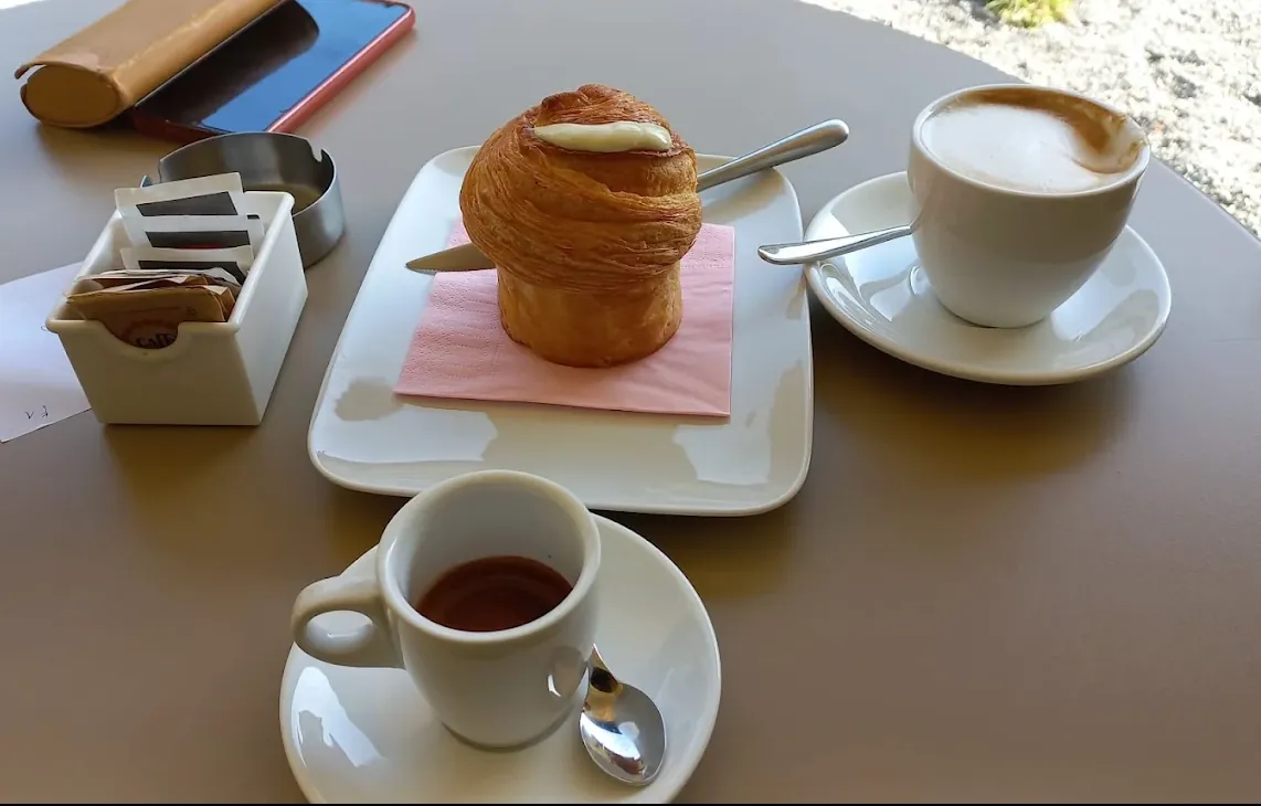 Caffè, cappuccino e un lievitato sfogliato serviti al tavolo