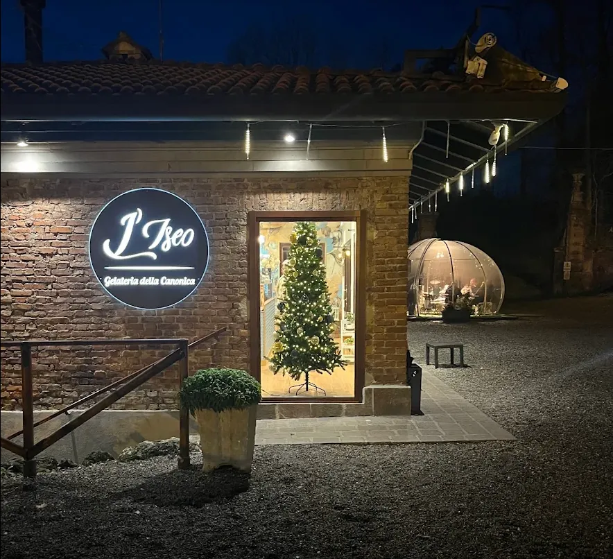 L’ingresso de L’Iseo illuminato la sera, con l’insegna sulla parete in mattoni